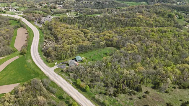 an aerial view of residential houses with outdoor space and trees
