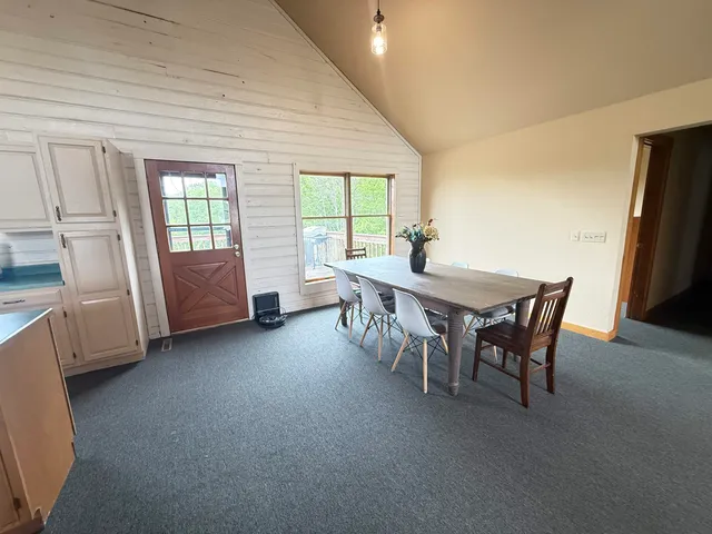 a dining room with furniture and a floor to ceiling window