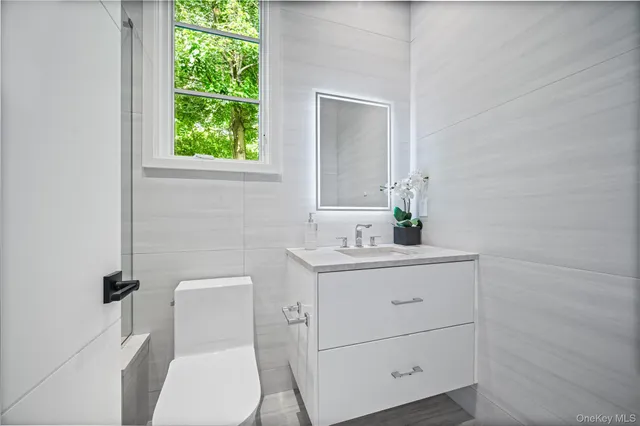 a bathroom with a toilet sink and mirror