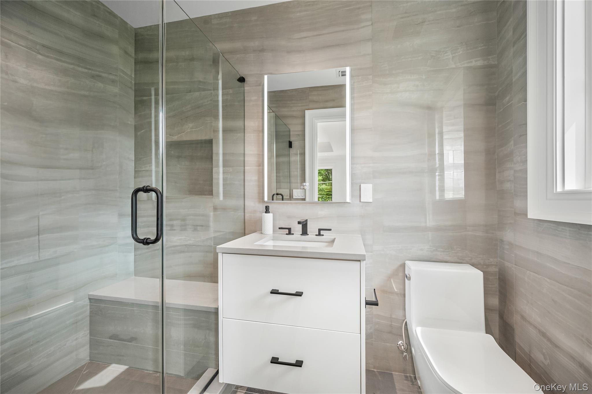 7 Mirrielees Road Great Neck, NY 11021 - Photo 40 of 47 a bathroom with a toilet sink vanity and mirror