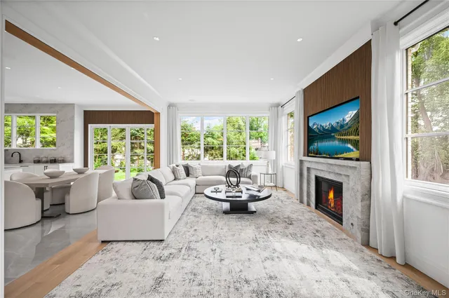 a living room with furniture a flat screen tv and a fireplace