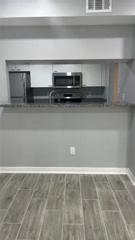 a kitchen with stainless steel appliances granite countertop a stove and a microwave