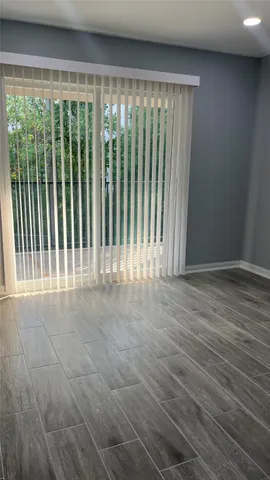 a room with a wooden floor and potted plant