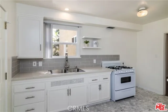 a kitchen with white cabinets and white appliances