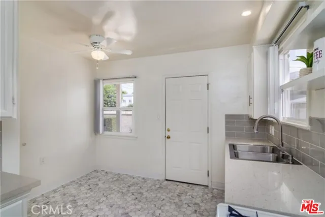 a kitchen with stainless steel appliances a sink a refrigerator and a window