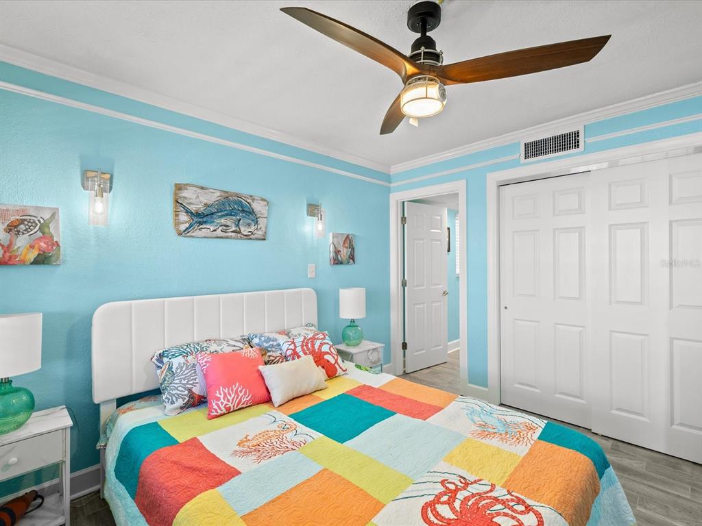205 Dolphin Point, Unit 4 Clearwater Beach, FL 33767 - Photo 11 of 23 a bedroom with a bed and a chandelier