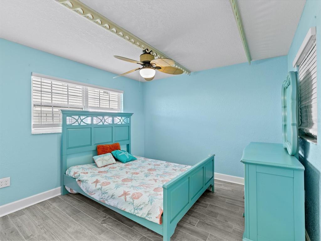 205 Dolphin Point, Unit 4 Clearwater Beach, FL 33767 - Photo 13 of 23 a bedroom with a bed and a chandelier