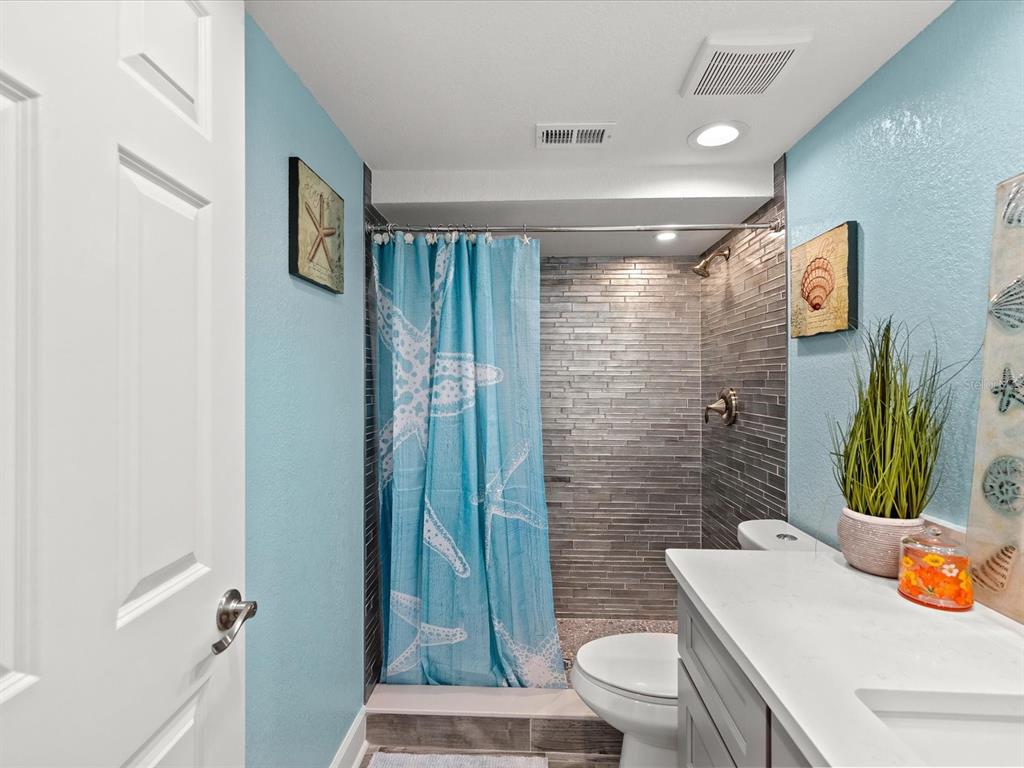 205 Dolphin Point, Unit 4 Clearwater Beach, FL 33767 - Photo 15 of 23 a bathroom with a sink a toilet and shower