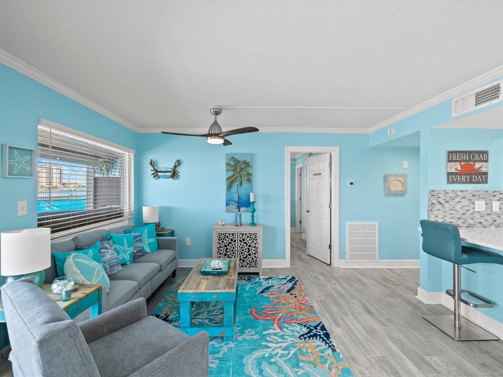 205 Dolphin Point, Unit 4 Clearwater Beach, FL 33767 - Photo 9 of 23 a living room with furniture and wooden floor