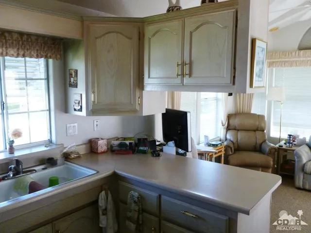 a kitchen with stainless steel appliances a sink a stove and white cabinets
