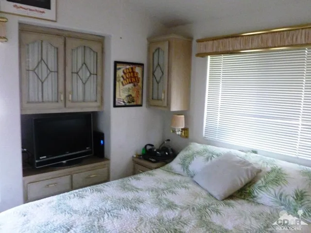 a bedroom with a bed and a television
