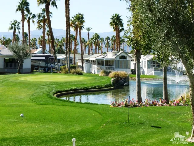 a front view of a house with garden and trees