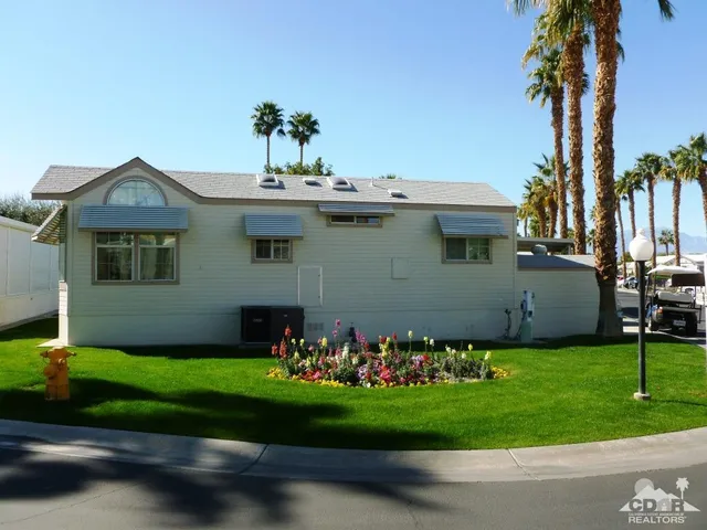 a front view of a house with a garden and plants