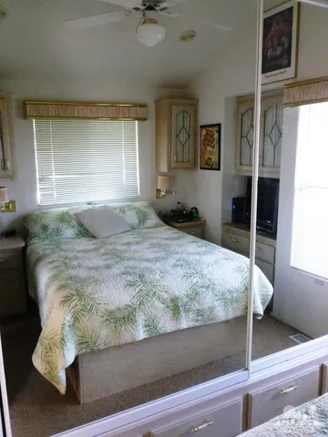 a bedroom with a bed and mirror