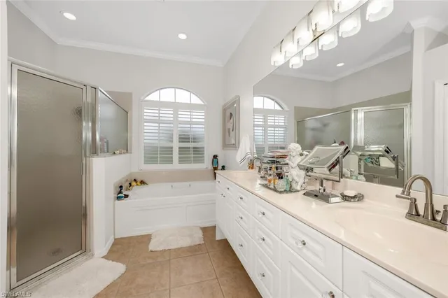 a bathroom with double vanity sinks a large mirror and a bathtub