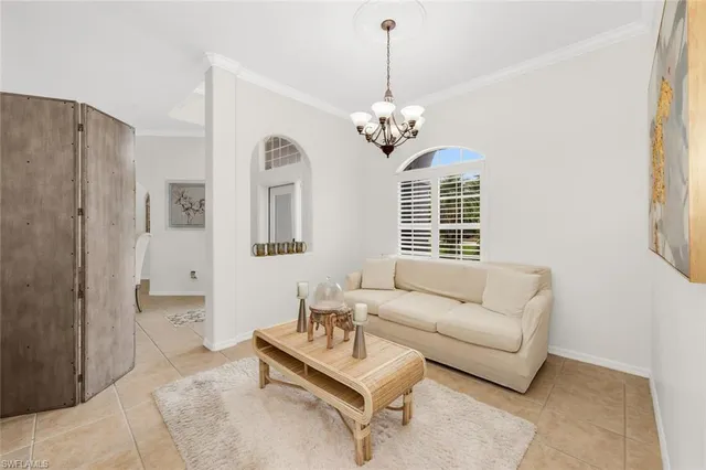 a living room with furniture chandelier and a window