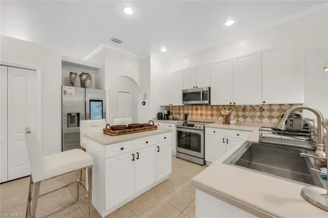 a kitchen with granite countertop a sink stove and refrigerator