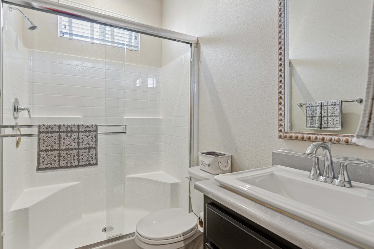 3264 Showcase Way Modesto, CA 95356 - Photo 16 of 31 a bathroom with a granite countertop sink a toilet a mirror and shower