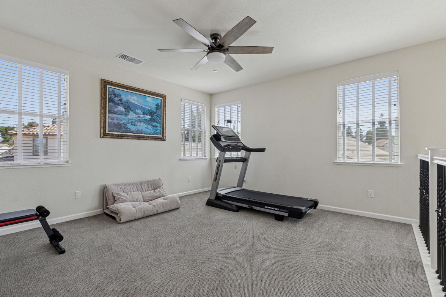 3264 Showcase Way Modesto, CA 95356 - Photo 18 of 31 a room with gym equipment and a ceiling fan