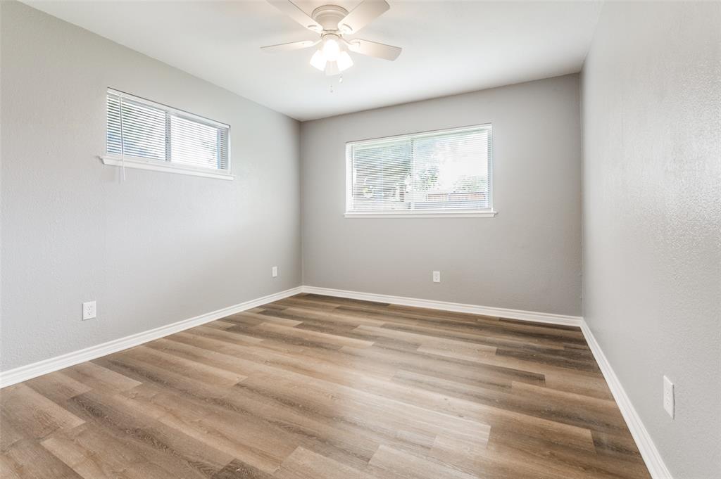 728 Oceanview Drive Dallas, TX 75232 - Photo 17 of 24 a view of an empty room with wooden floor and a window