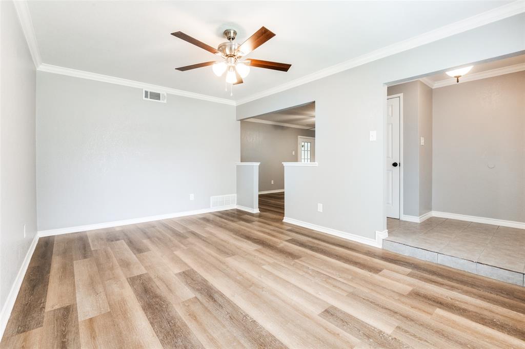 728 Oceanview Drive Dallas, TX 75232 - Photo 4 of 24 a view of a big room with wooden floor and a ceiling fan