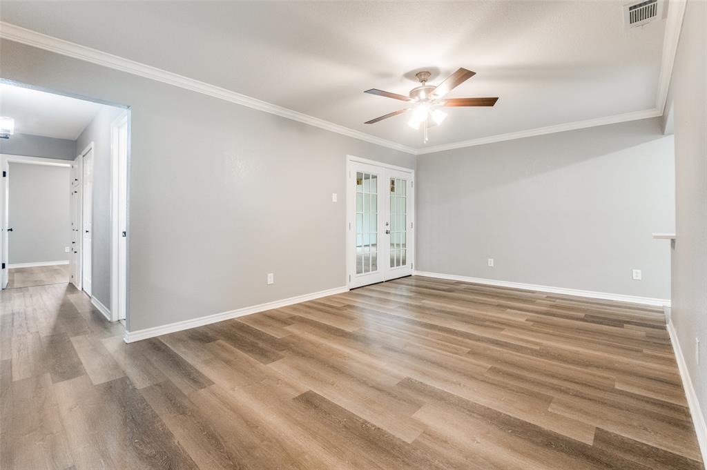 728 Oceanview Drive Dallas, TX 75232 - Photo 6 of 24 a view of an empty room with wooden floor and a ceiling fan