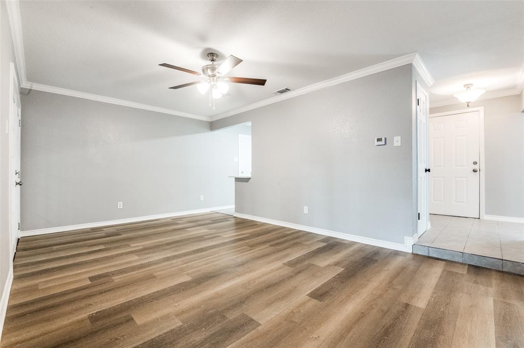 728 Oceanview Drive Dallas, TX 75232 - Photo 7 of 24 a view of an empty room with wooden floor and a ceiling fan
