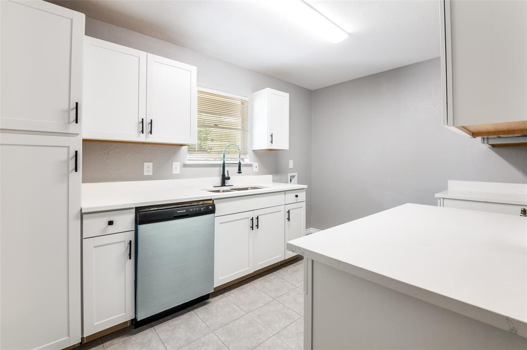 728 Oceanview Drive Dallas, TX 75232 - Photo 9 of 24 a kitchen with a sink dishwasher and white cabinets with wooden floor