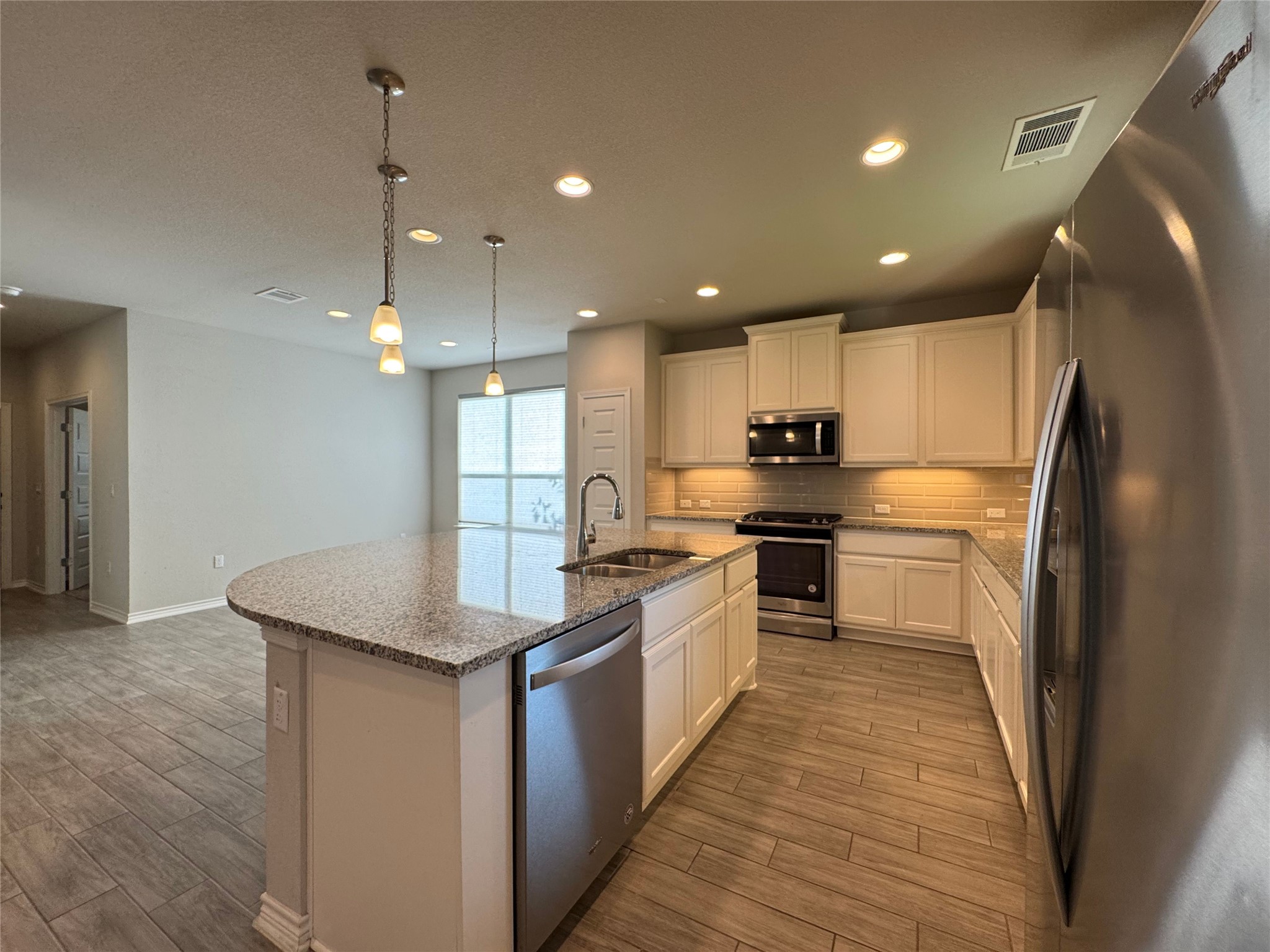 14100 McCoy Loop, Unit 1 Austin, TX 78717 - Photo 6 of 39 A well-appointed kitchen features stainless steel appliances, granite countertops, and modern pendant lighting.