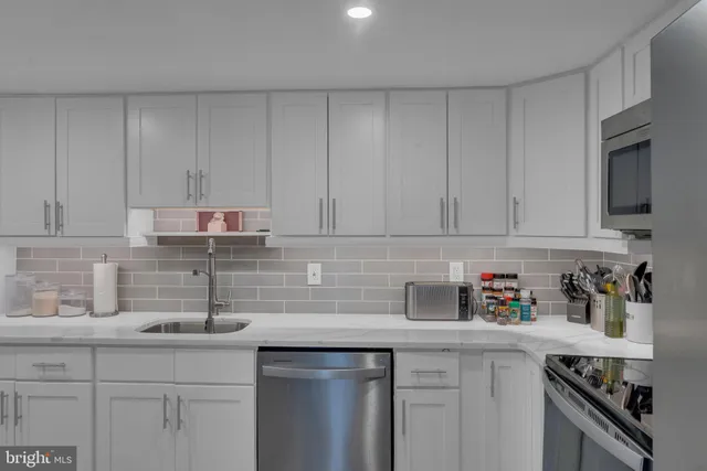 a kitchen with stainless steel appliances granite countertop a sink a stove a microwave and cabinets