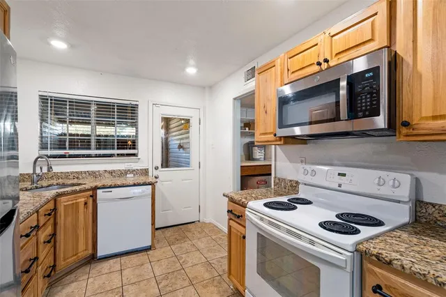 a kitchen with stainless steel appliances granite countertop a refrigerator sink and stove