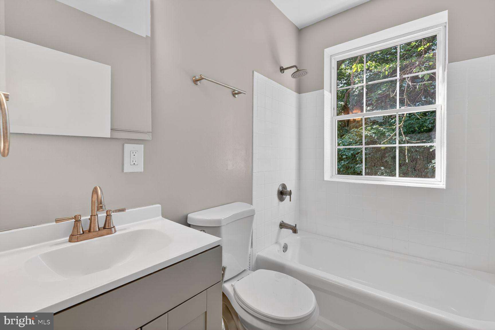 1008 Rittenhouse Street Northwest, Unit 15 Washington, DC 20011 - Photo 25 of 39 a bathroom with a sink toilet a mirror and shower