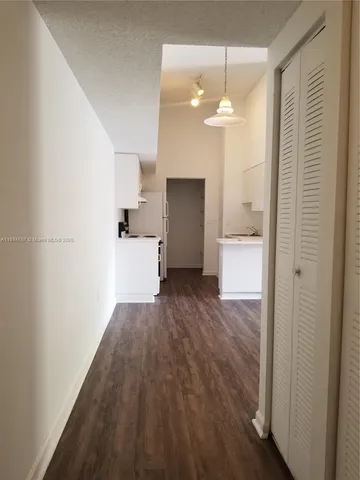 a view of a room with a hardwood floor and a ceiling fan