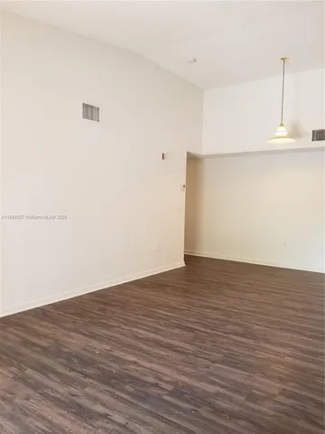 a view of a room with wooden floor and white wall
