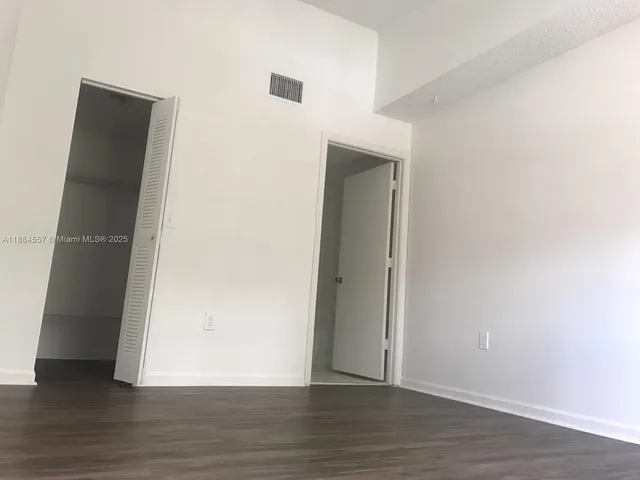 an empty room with wooden floor and closet