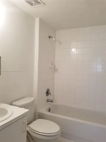 a white toilet and tub sitting next to a bathroom sink
