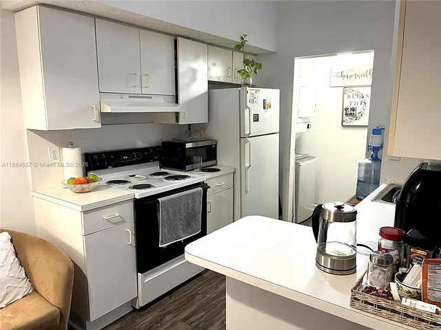 a kitchen with a sink a refrigerator and cabinets