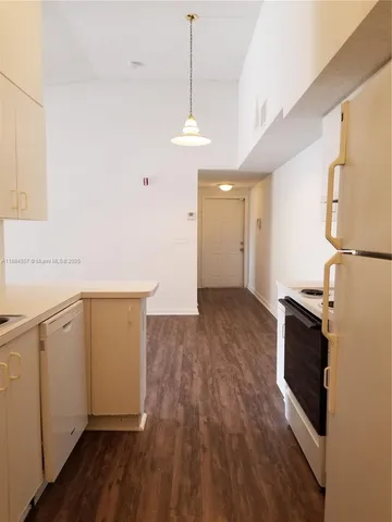 a kitchen with granite countertop a stove a sink and a refrigerator