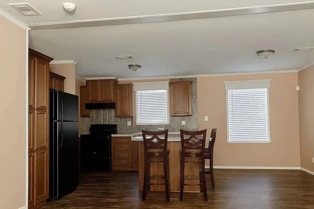 a kitchen with stainless steel appliances a refrigerator a stove a sink and dishwasher with wooden floor