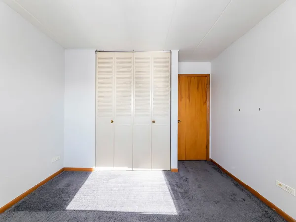an empty room with a fireplace and windows