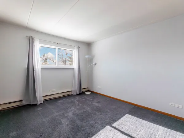 a view of an empty room with closet and a wooden floor