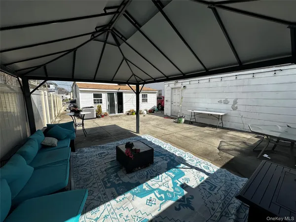 a view of a backyard with table and chairs under an umbrella