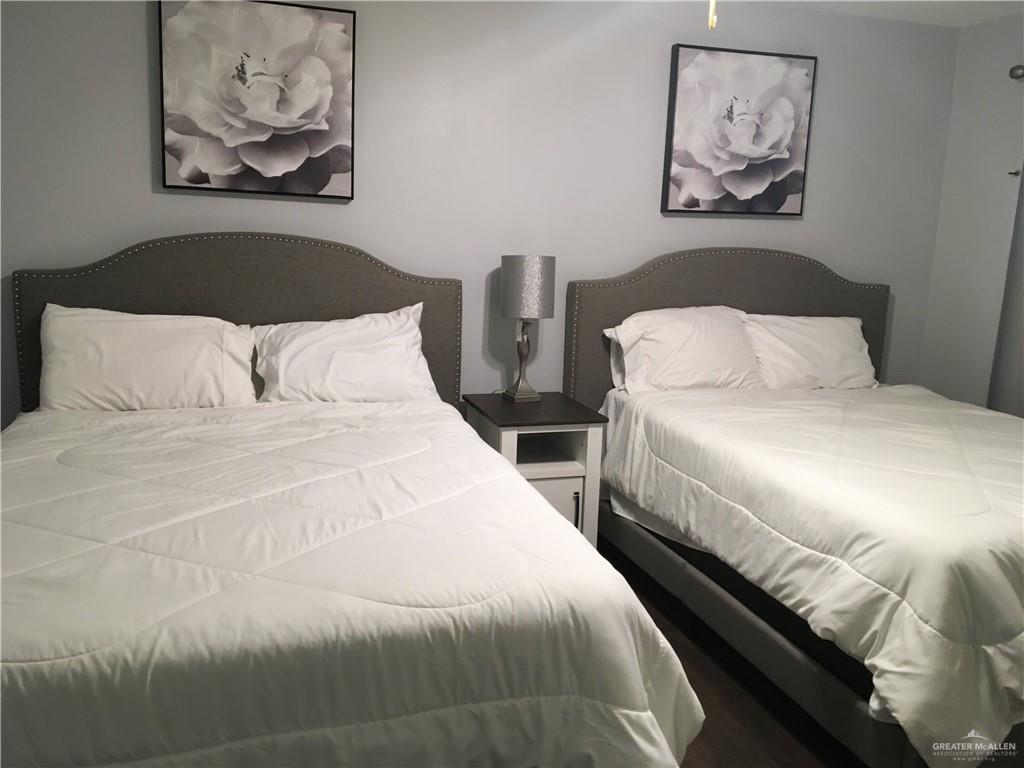 700 Fern Street, Unit 4 McAllen, TX 78504 - Photo 11 of 14 a bedroom with 2 bed and a painting on the wall