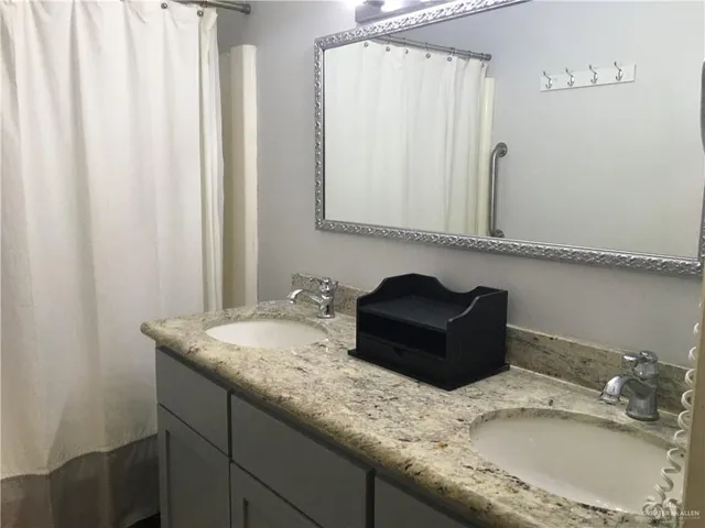 a bathroom with a granite countertop sink and a mirror