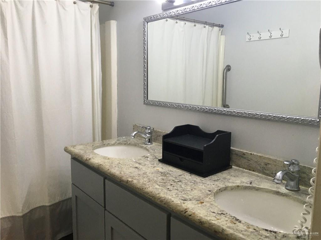 700 Fern Street, Unit 4 McAllen, TX 78504 - Photo 12 of 14 a bathroom with a granite countertop sink and a mirror