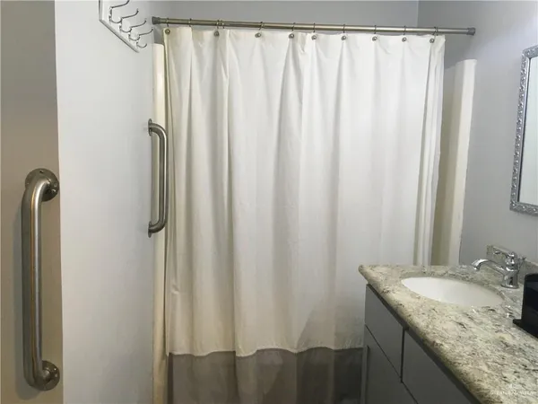 a bathroom with a granite countertop and shower curtain