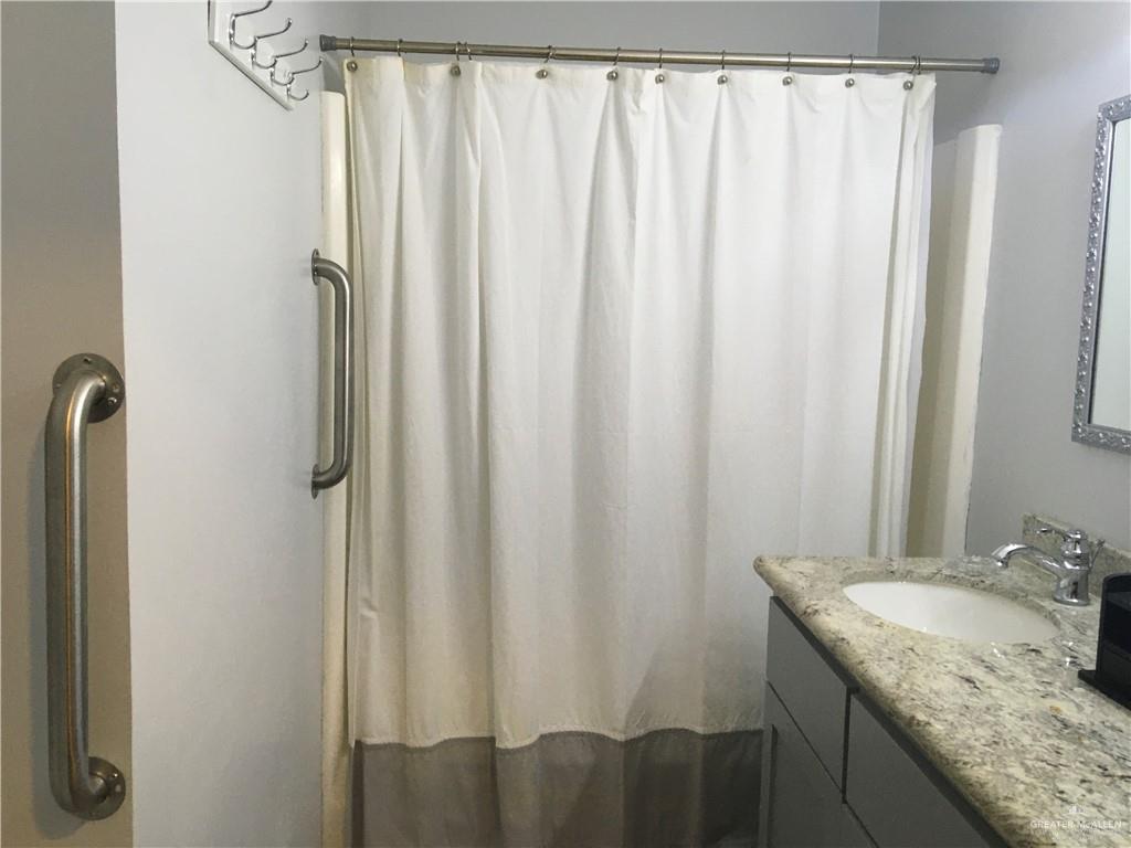 700 Fern Street, Unit 4 McAllen, TX 78504 - Photo 13 of 14 a bathroom with a granite countertop and shower curtain