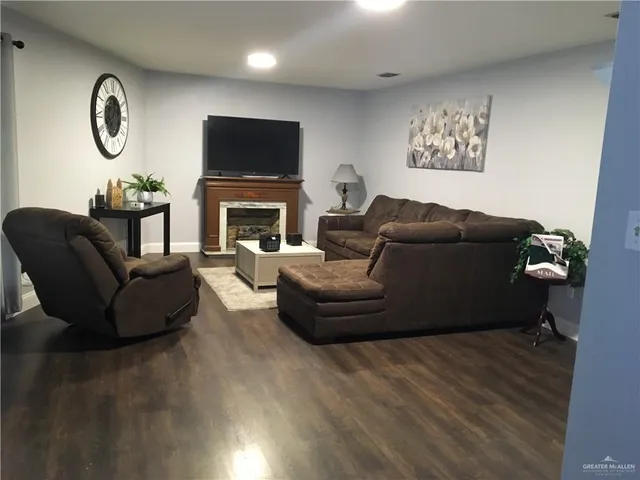 a living room with furniture a flat screen tv and a fireplace