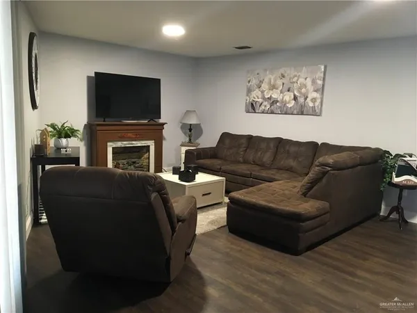 a living room with furniture a flat screen tv and a fireplace