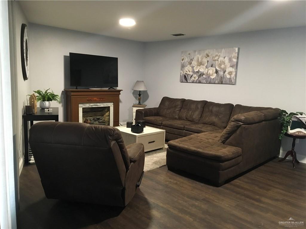 700 Fern Street, Unit 4 McAllen, TX 78504 - Photo 6 of 14 a living room with furniture a flat screen tv and a fireplace